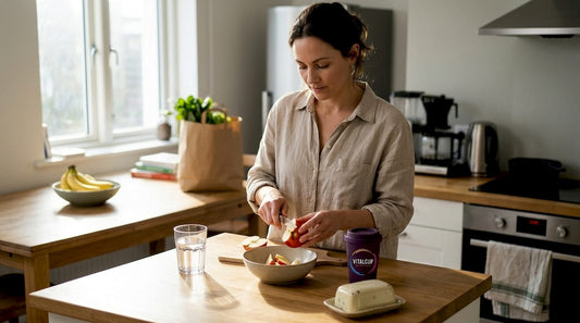 Dans une cuisine baignée de lumière, une femme découpe une pomme avec soin.