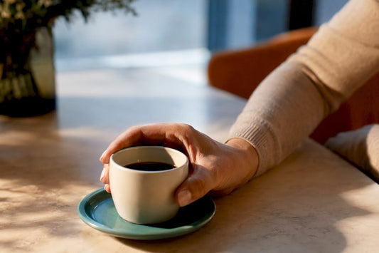 Main serrée autour d'une tasse de café
