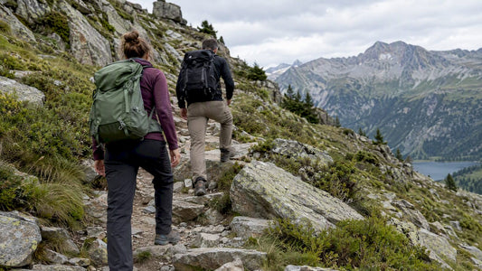 Deux marcheurs progressent sur un chemin caillouteux